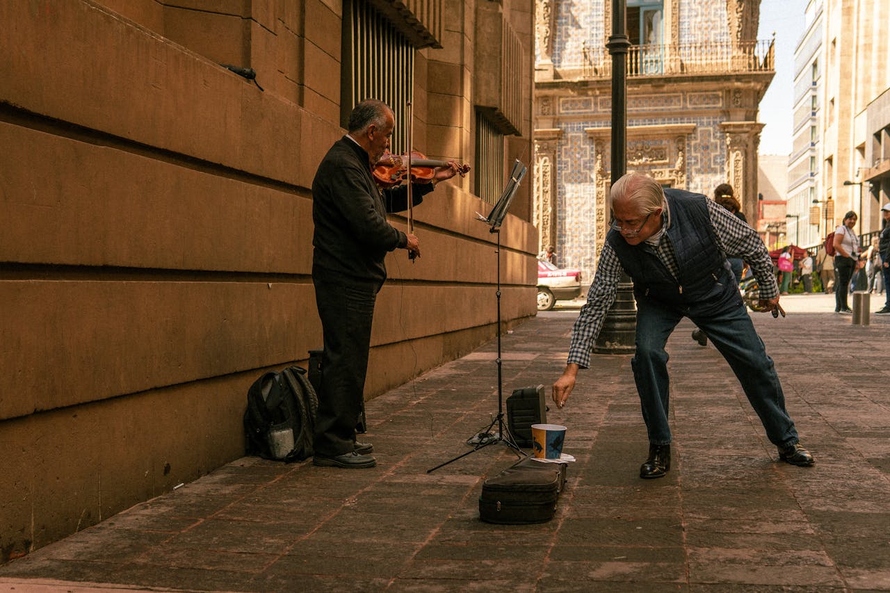 gallery-05 Elderly violinist playing on the streets of Ciudad de México with a passerby donating.