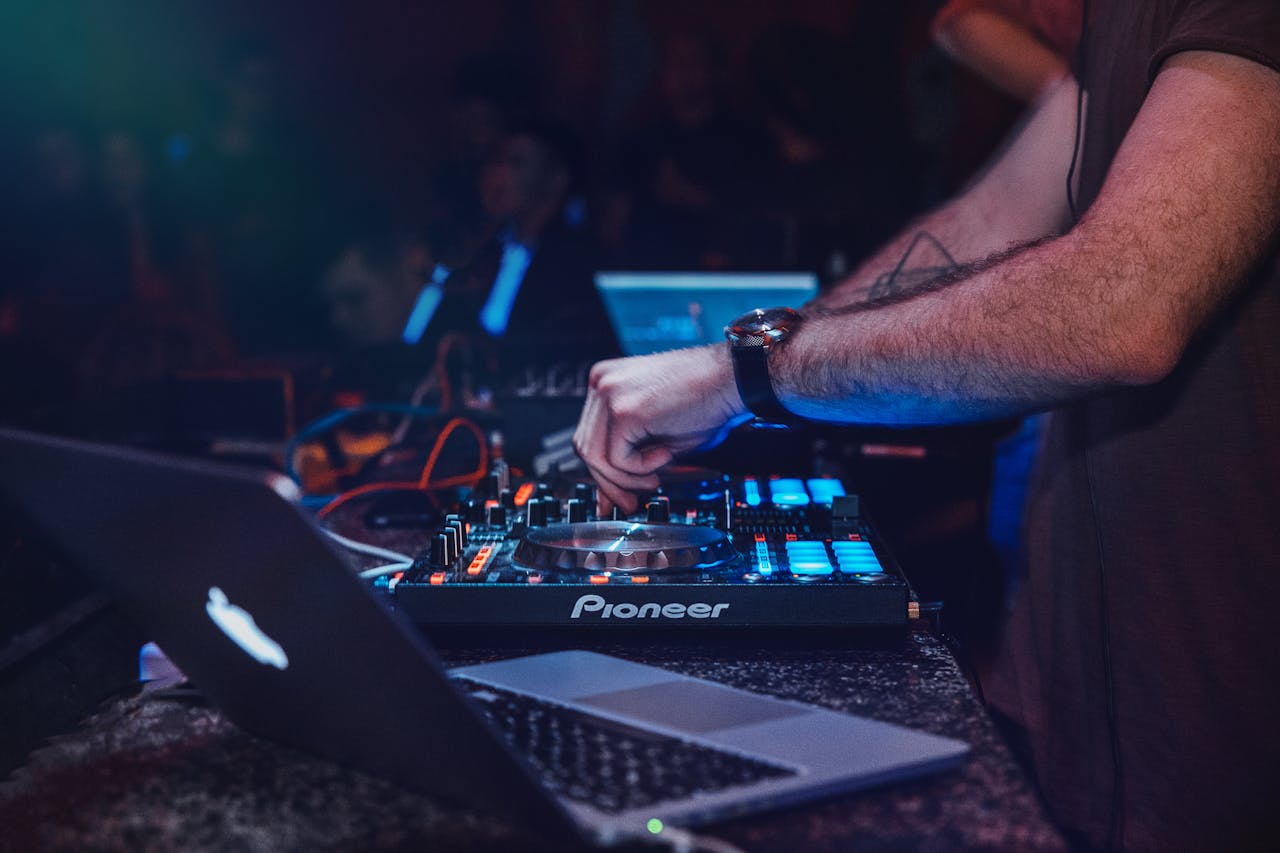 gallery-04 DJ performing with mixer in a vibrant nightclub setting. Perfect for entertainment and technology themes.